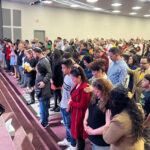 Personas de pie en el Templo Cristiano Iglesia de Dios, en Irving, Texas
