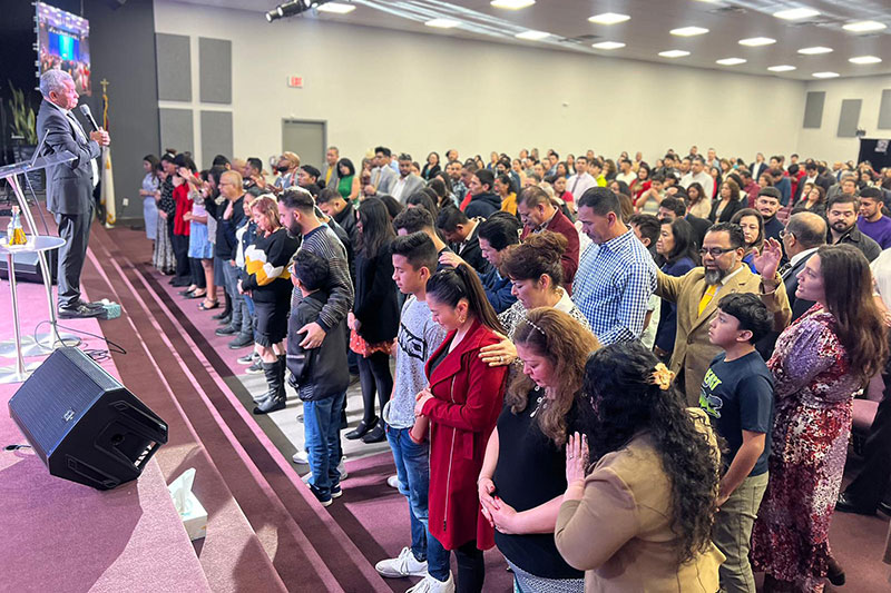 Personas de pie en el Templo Cristiano Iglesia de Dios, en Irving, Texas