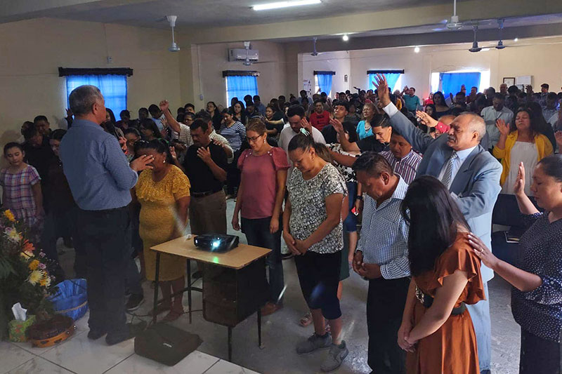 Dr Antonio Bolainez frente a grupo de creyentes en Iglesia