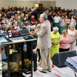 Dr. Antonio Bolainez orando por personas en el altar